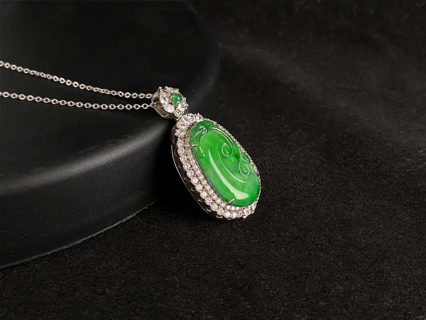 A vivid green spirit Ruyi jadeite pendant.