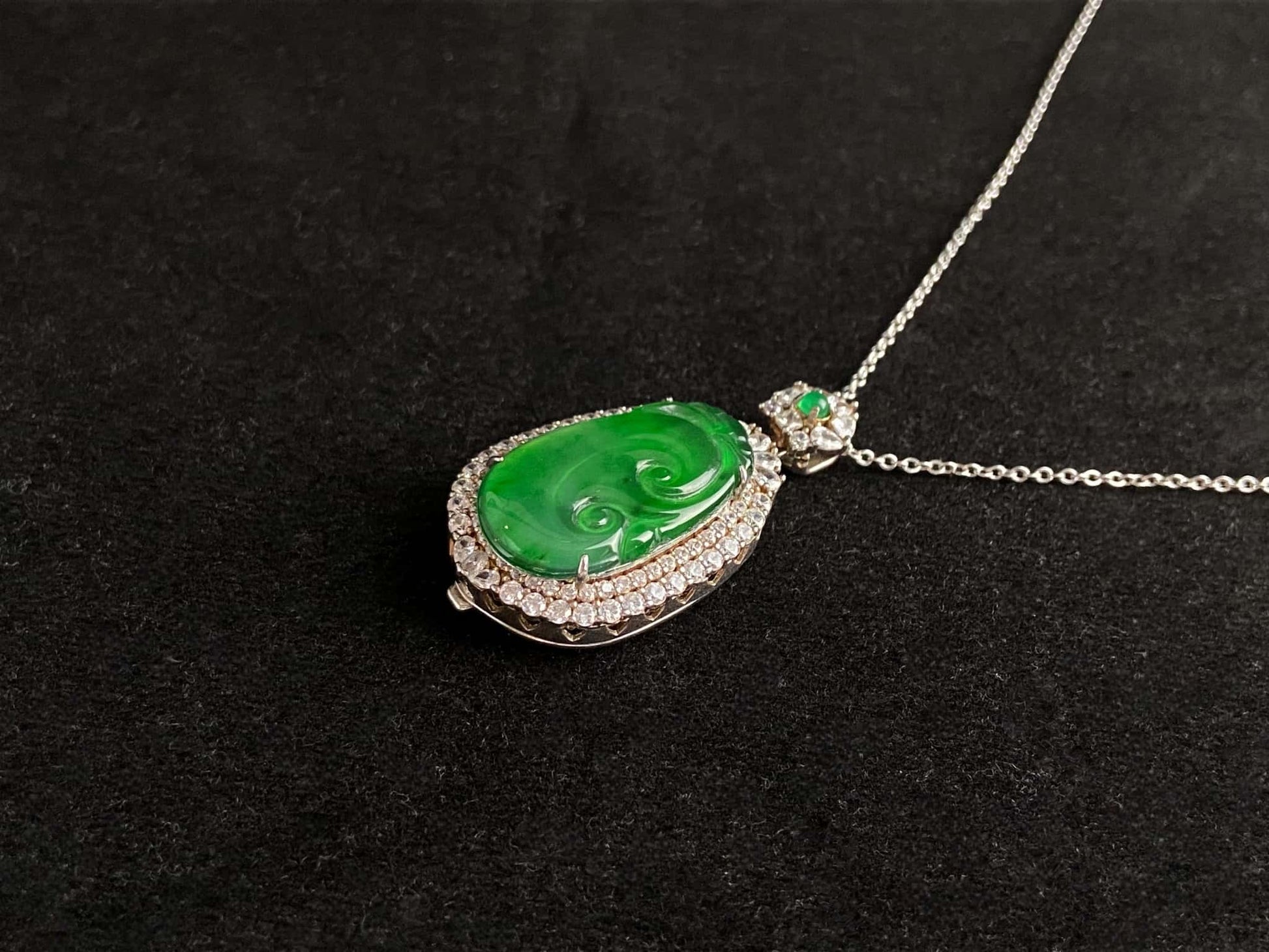 A vivid green spirit Ruyi jadeite pendant.