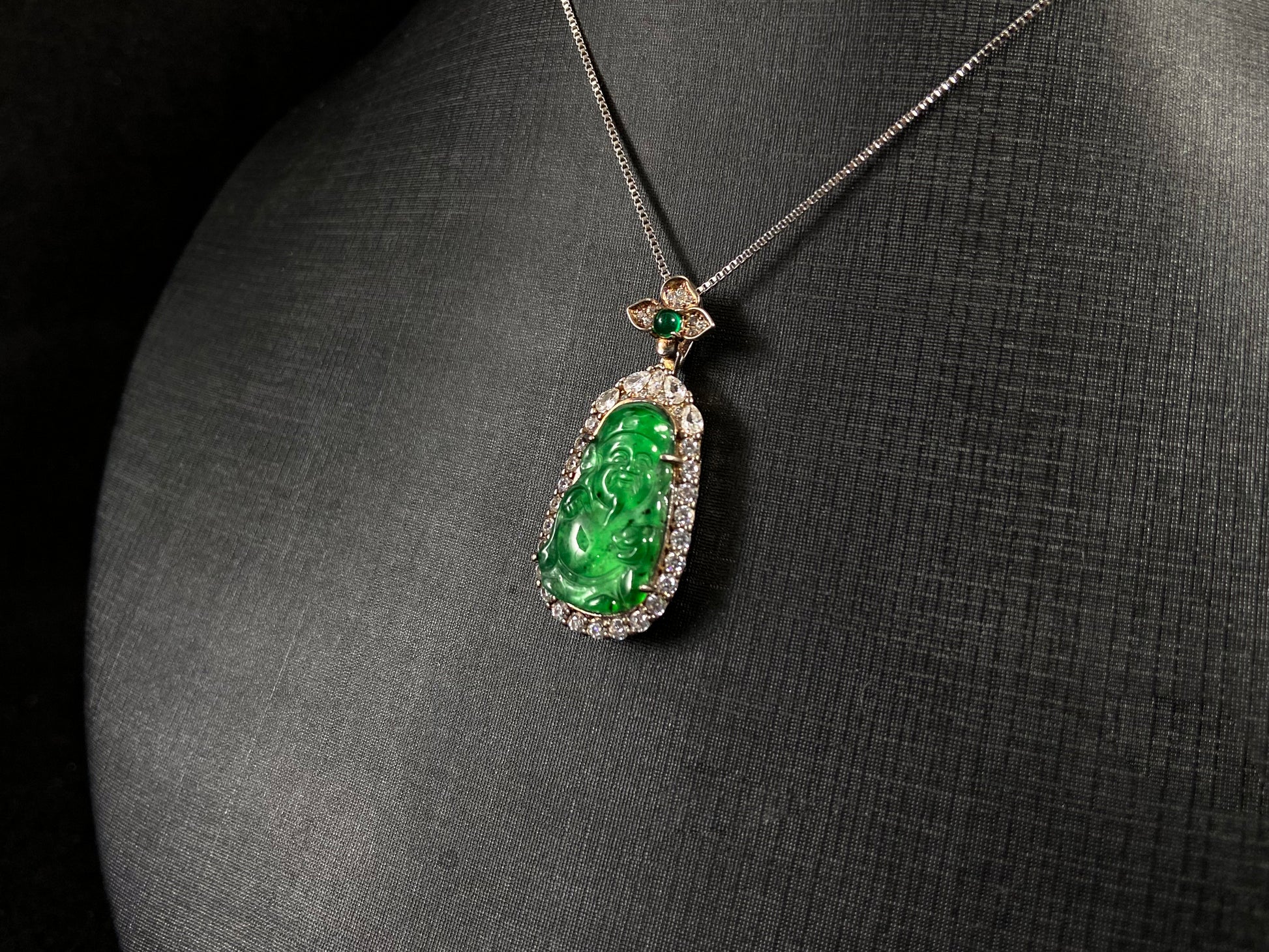 A green jade pendant depicting the God of Wealth, elegantly framed in 925 sterling silver.