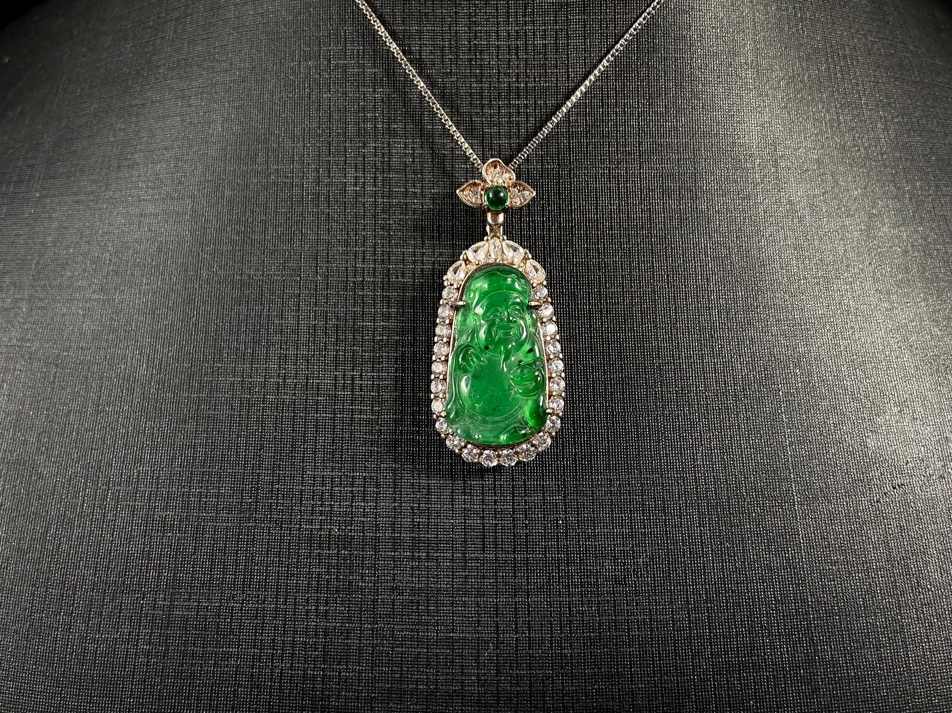 A green jade pendant depicting the God of Wealth, elegantly framed in 925 sterling silver.