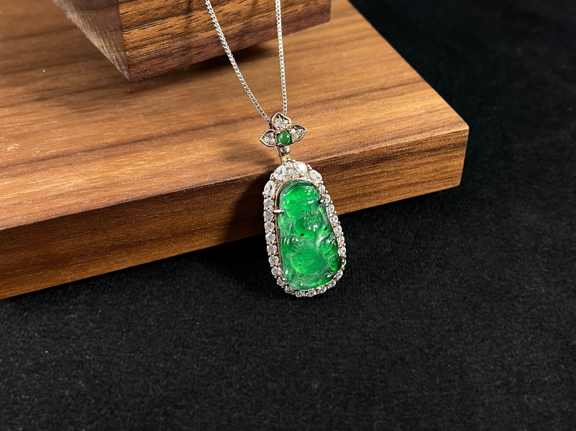 A green jade pendant depicting the God of Wealth, elegantly framed in 925 sterling silver.