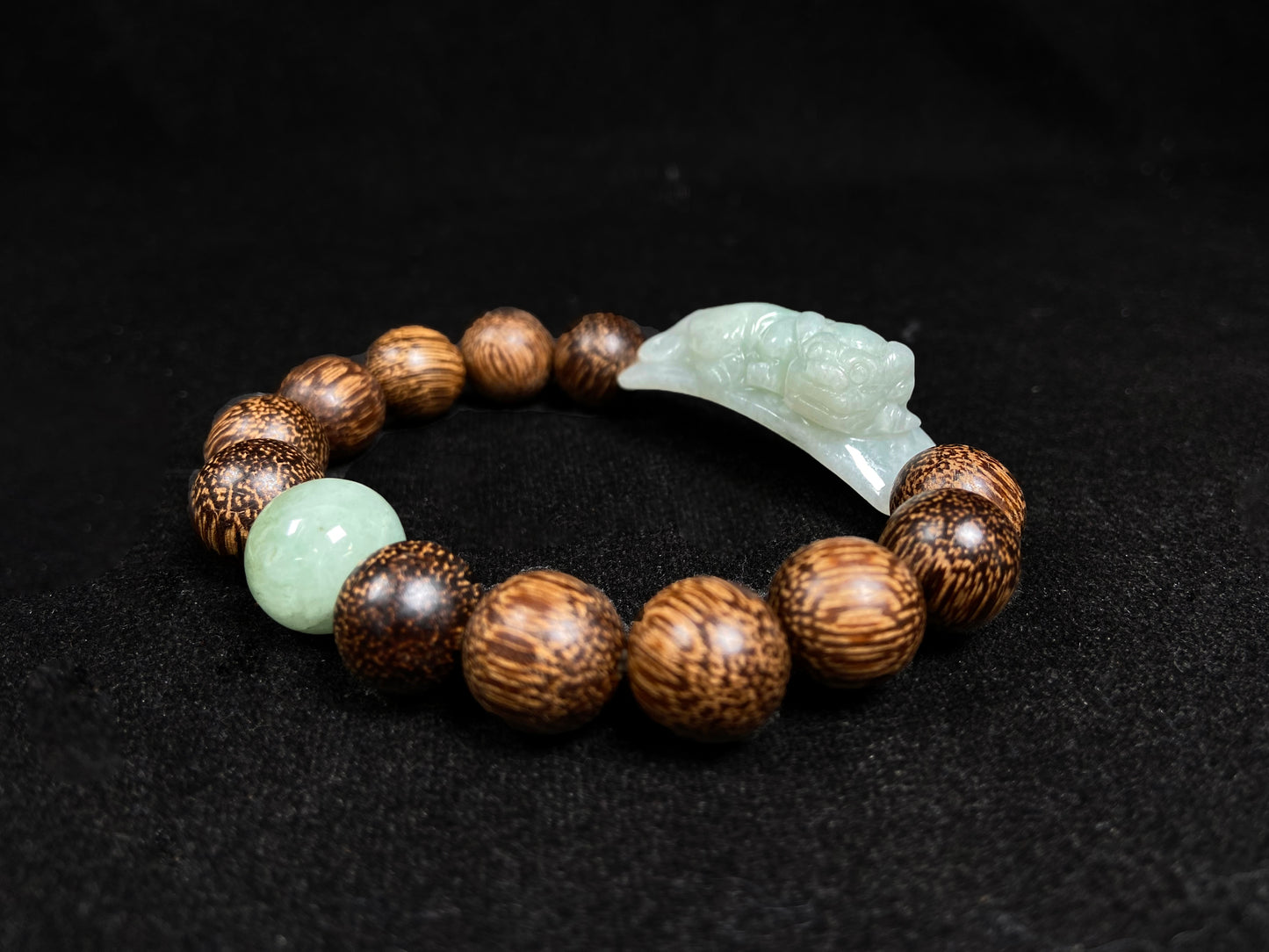 A white green Pixiu’s blessing jadeite agarwood bracelet.