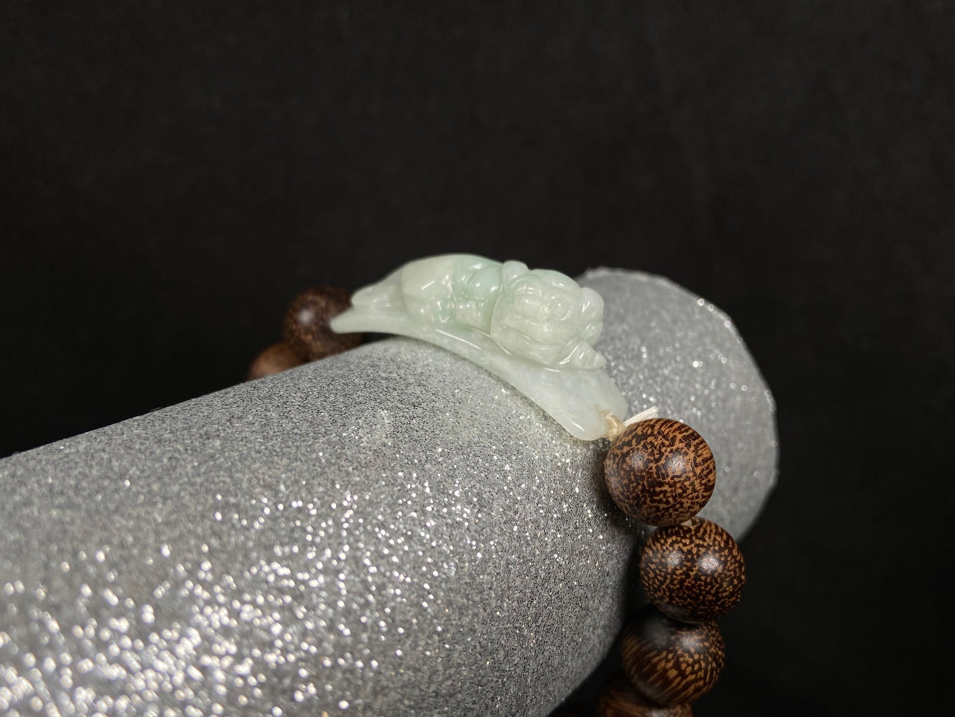 A white green Pixiu’s blessing jadeite agarwood bracelet.