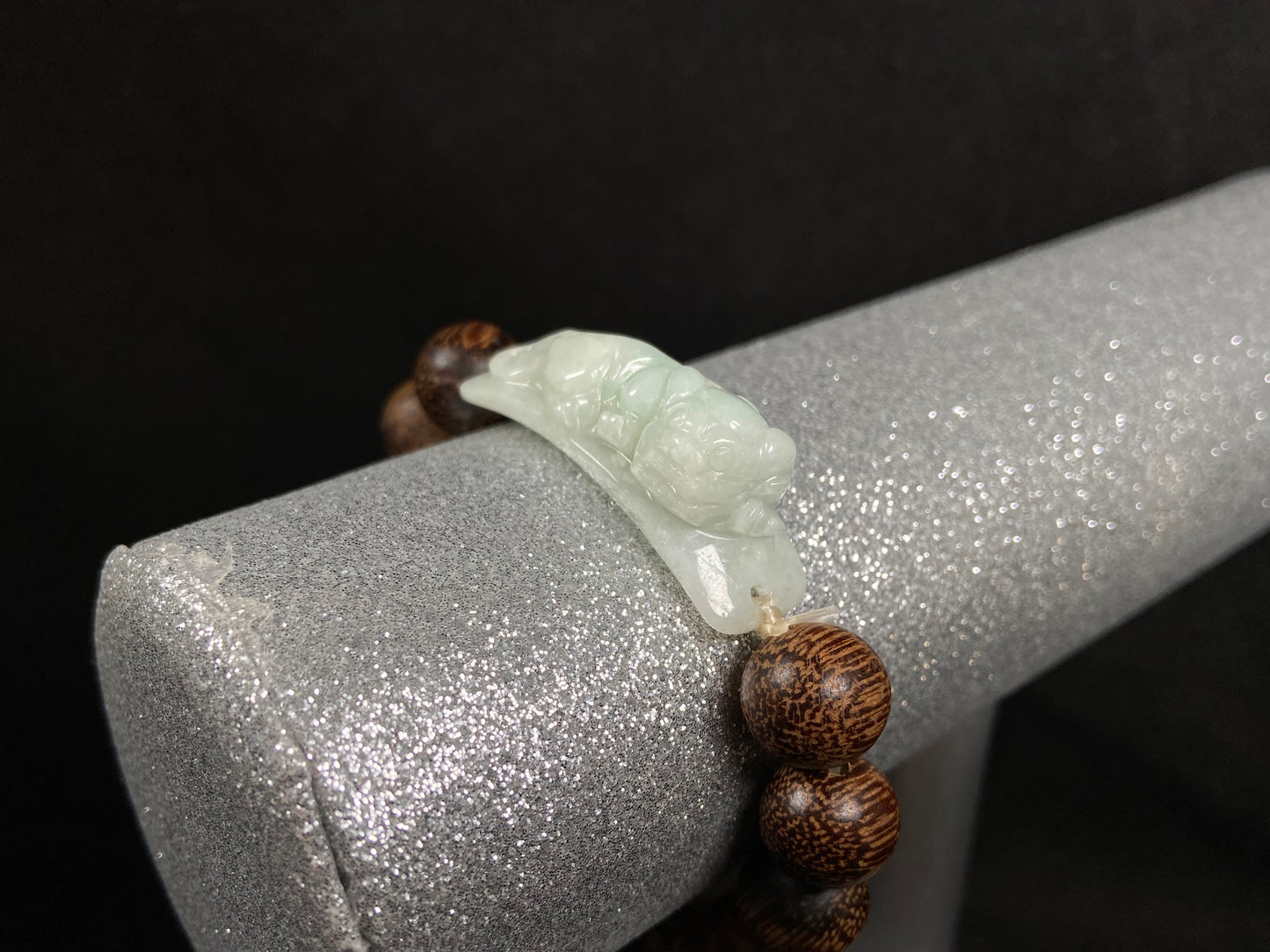 A white green Pixiu’s blessing jadeite agarwood bracelet.