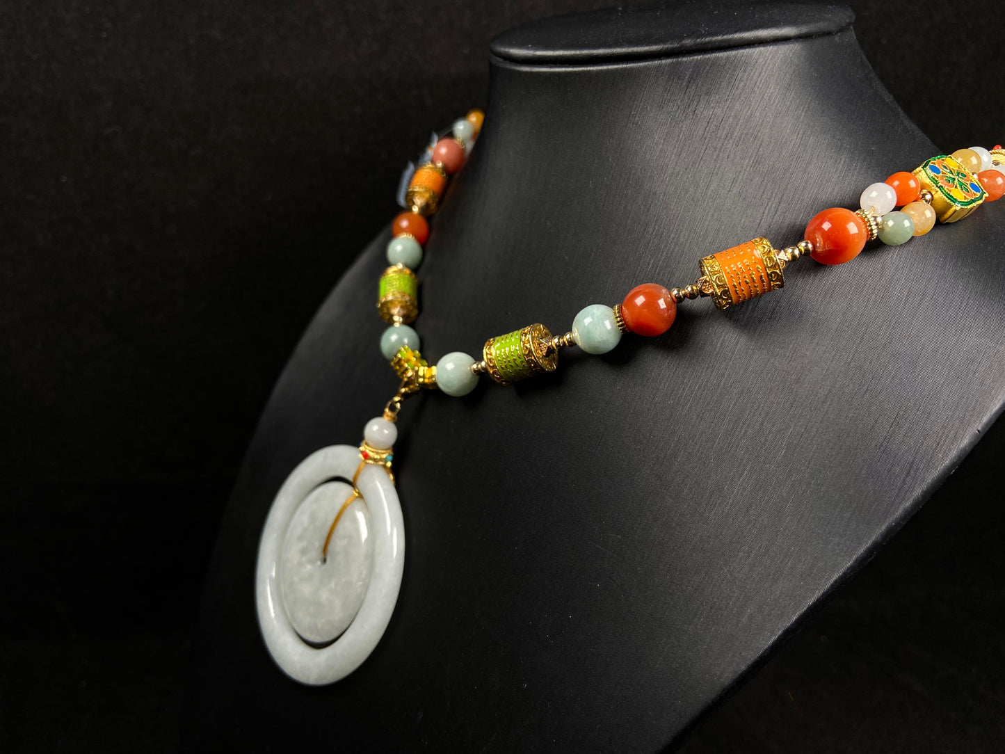 A sleek pale white double ring peace buckle jadeite pendant.