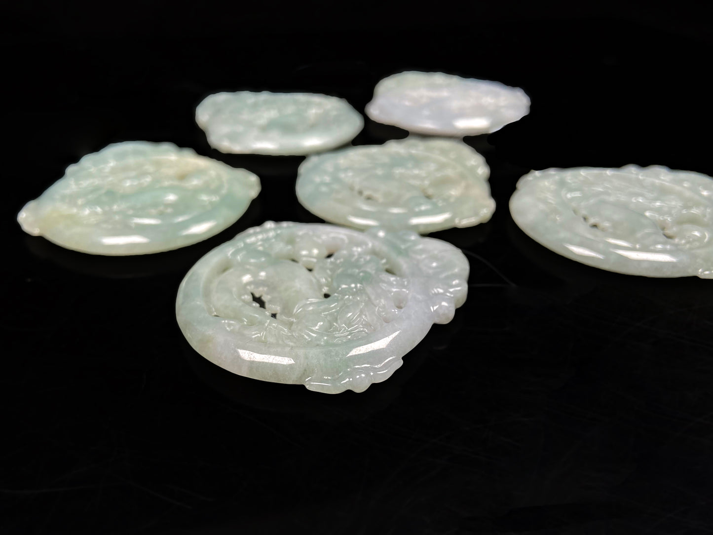 A pale green hollow dragon jadeite pendant.