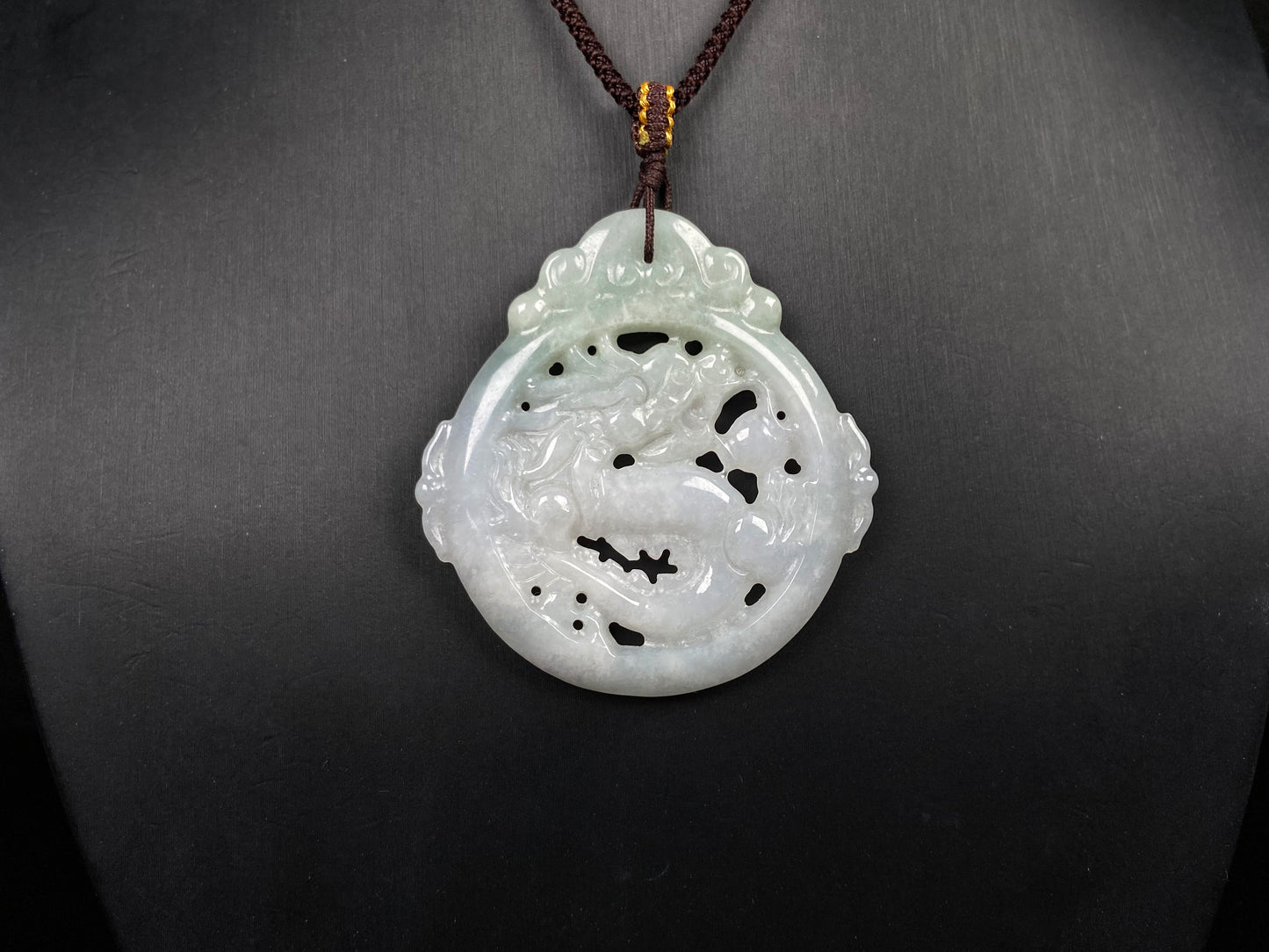 A pale green hollow dragon jadeite pendant.