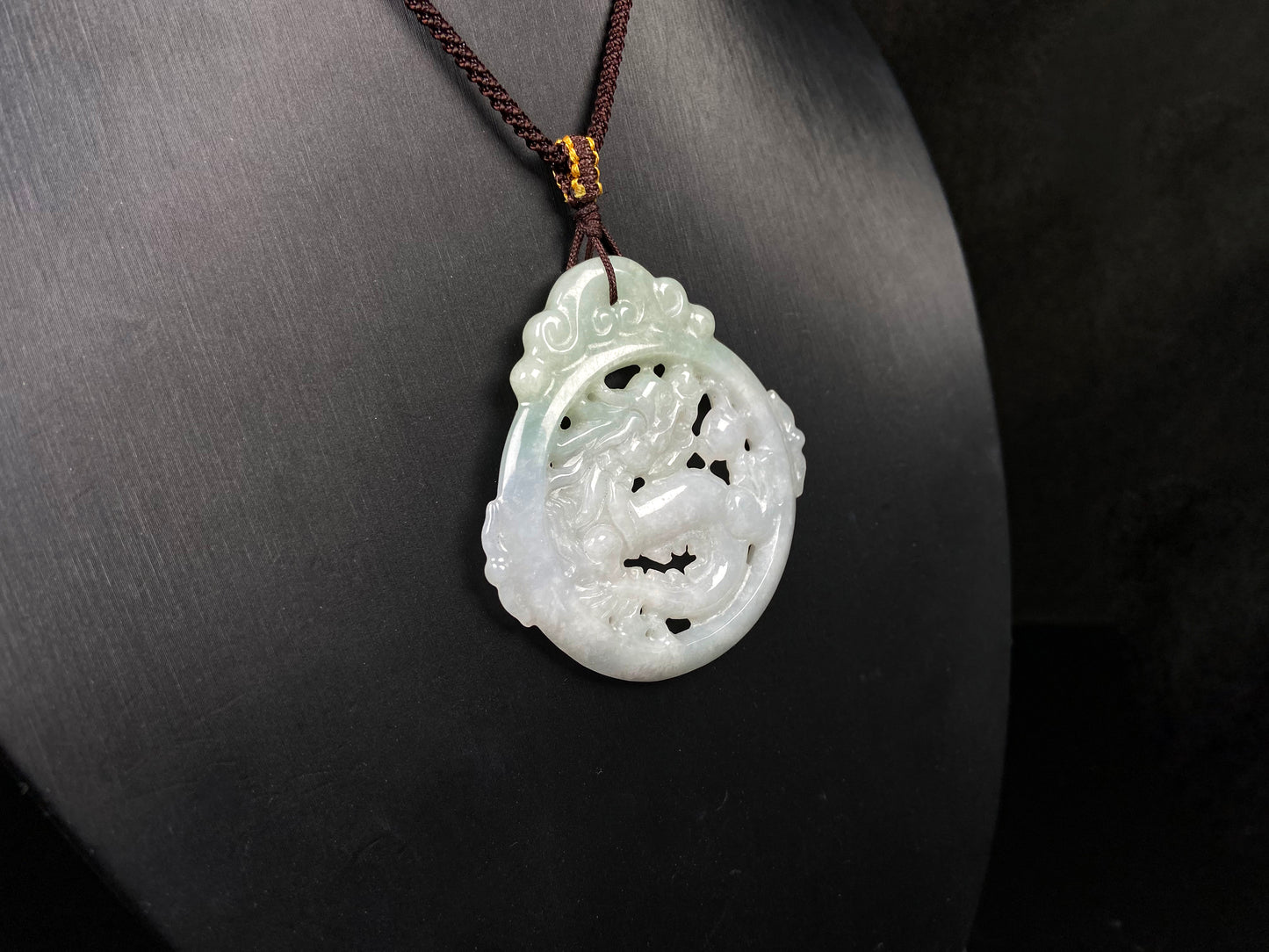 A pale green hollow dragon jadeite pendant.