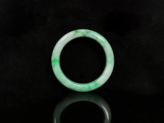 A soft white with fresh green streaks
jadeite bangle.