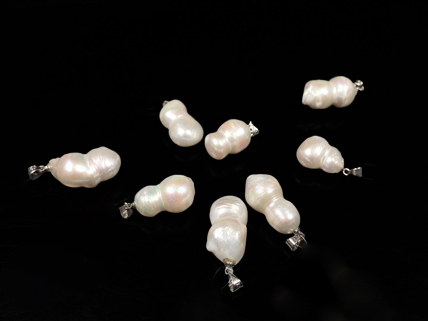 A group of milky white with blush overtones lucky gourd silhouette pearl pendant.
