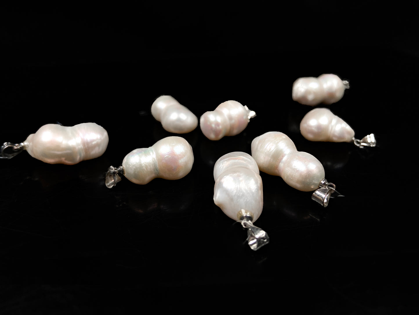 A group of milky white with blush overtones lucky gourd silhouette pearl pendant.