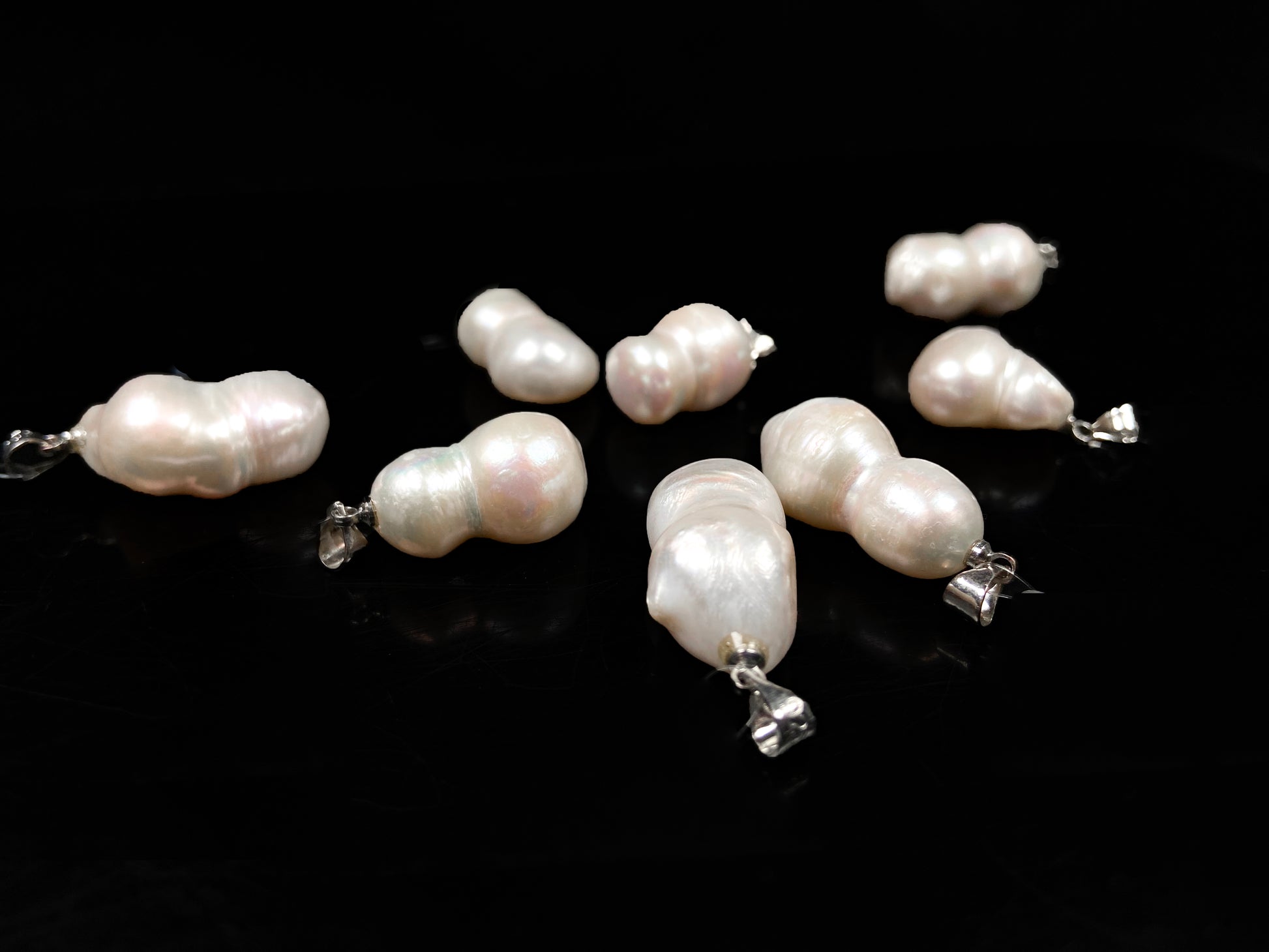 A group of milky white with blush overtones lucky gourd silhouette pearl pendant.