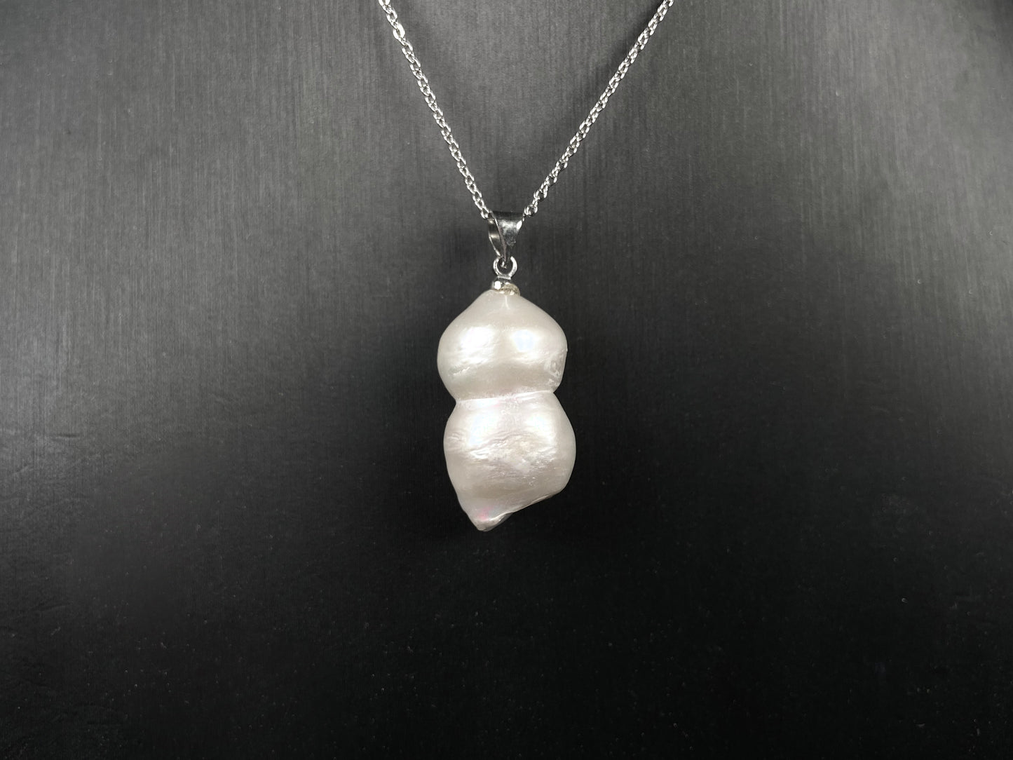 A milky white with blush overtones lucky gourd silhouette pearl pendant.