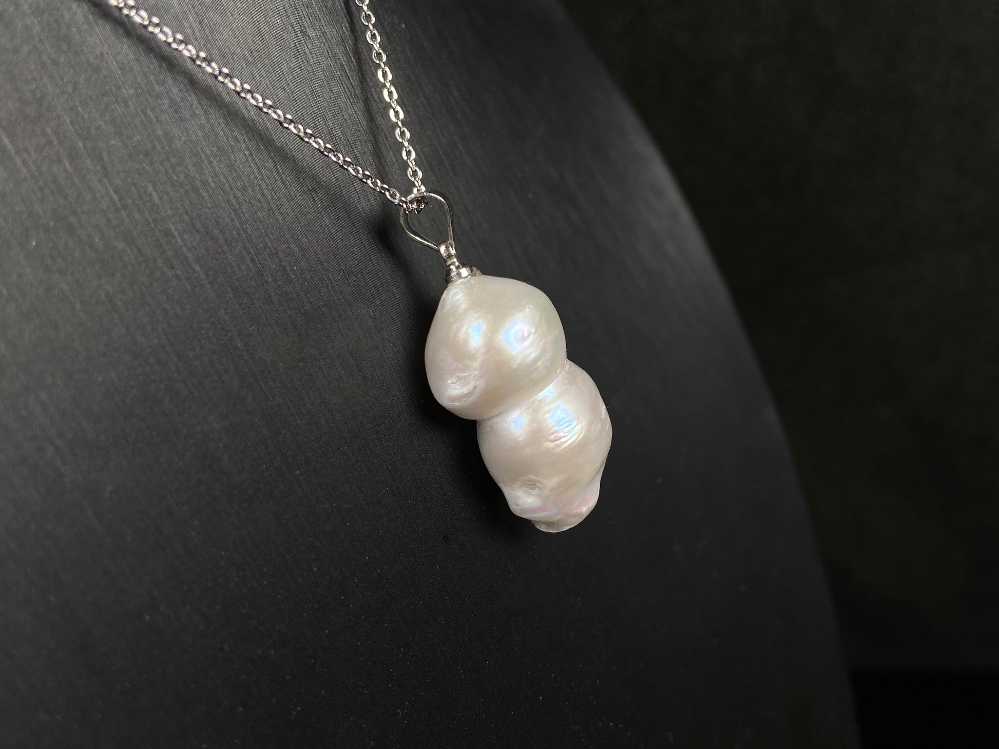 A milky white with blush overtones lucky gourd silhouette pearl pendant.