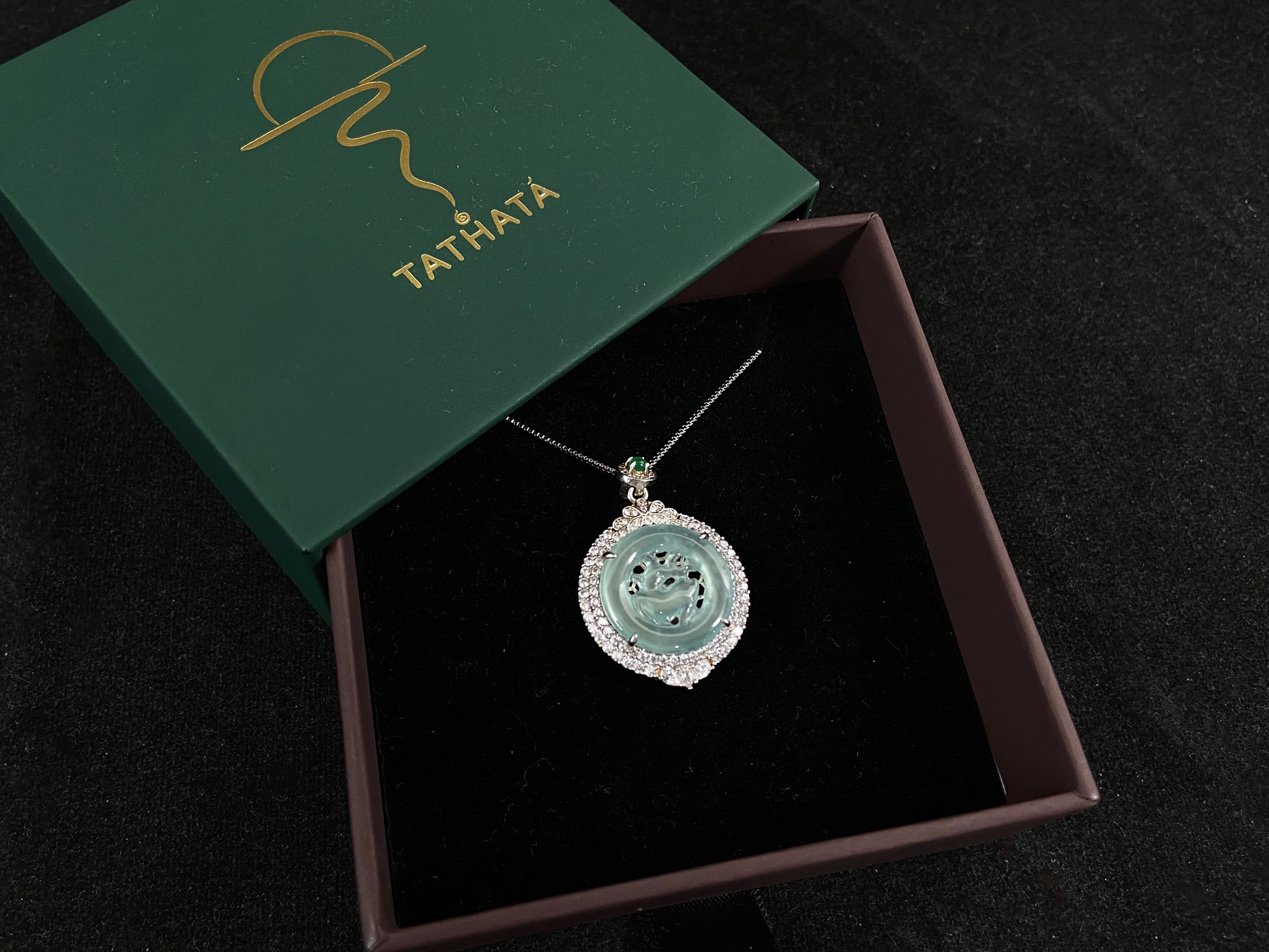 A circular pendant features a light green jade deer enclosed within a jade ring, all framed in 925 silver.