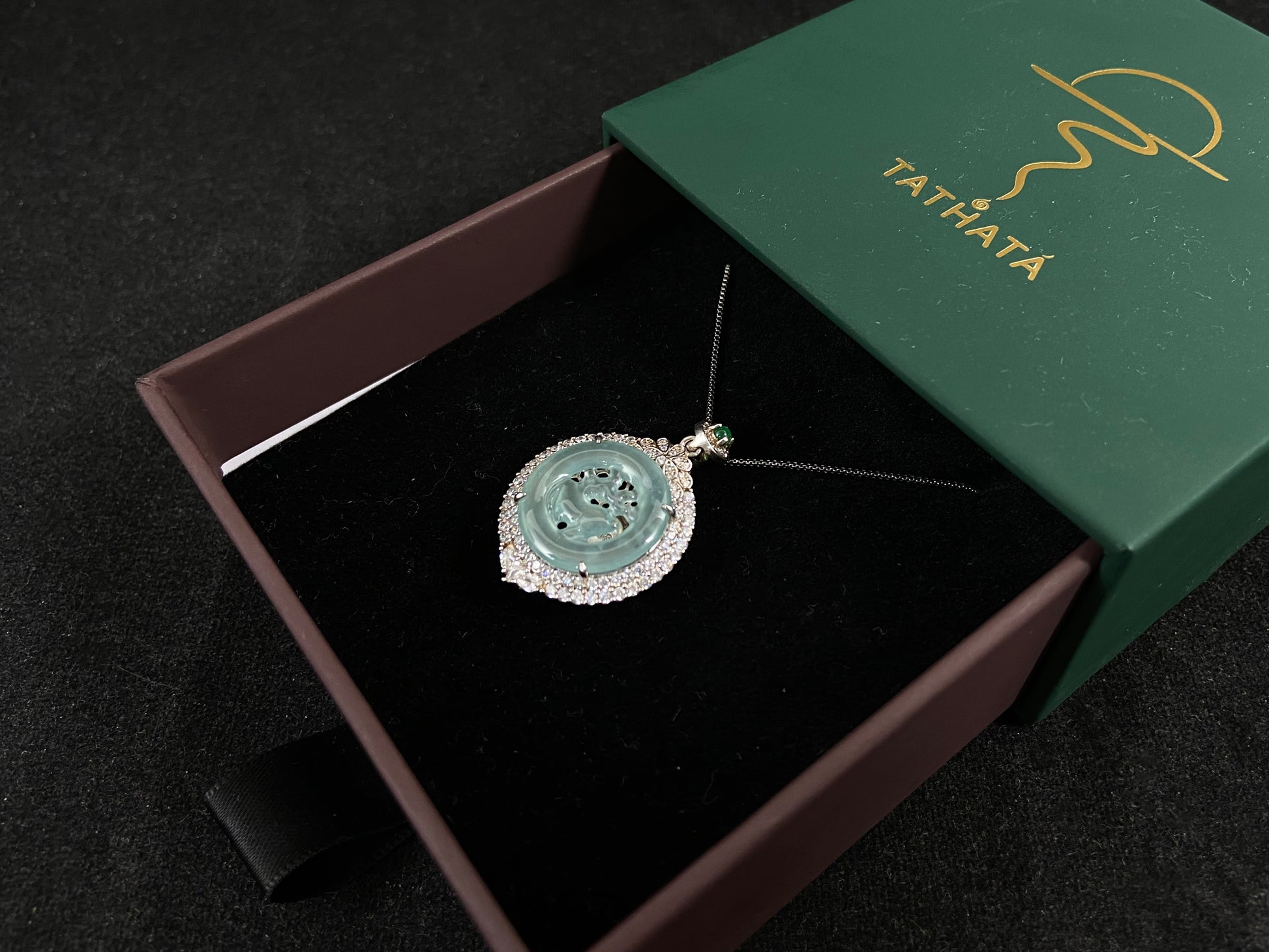 A circular pendant features a light green jade deer enclosed within a jade ring, all framed in 925 silver.