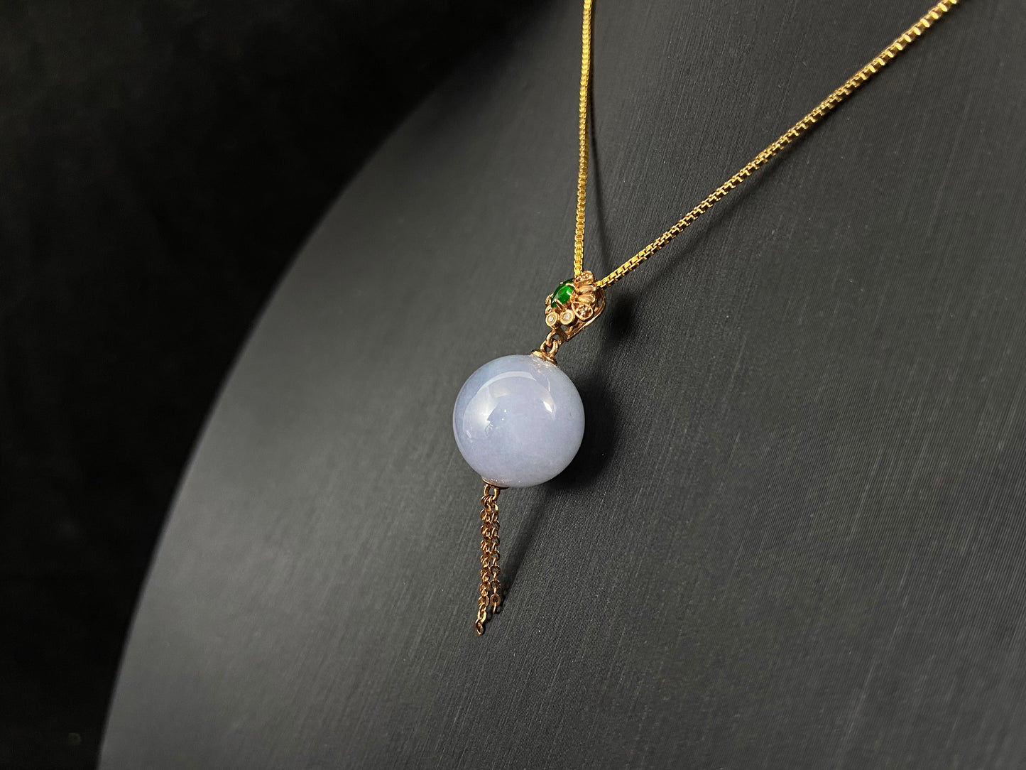 A semi-transparent, milky white jade bead is securely set using the nail-set technique