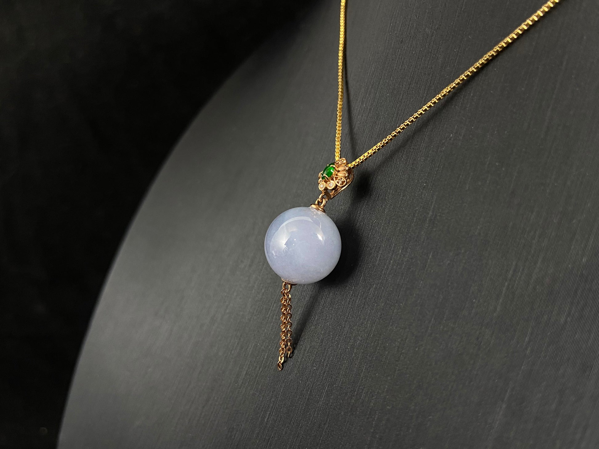 A semi-transparent, milky white jade bead is securely set using the nail-set technique