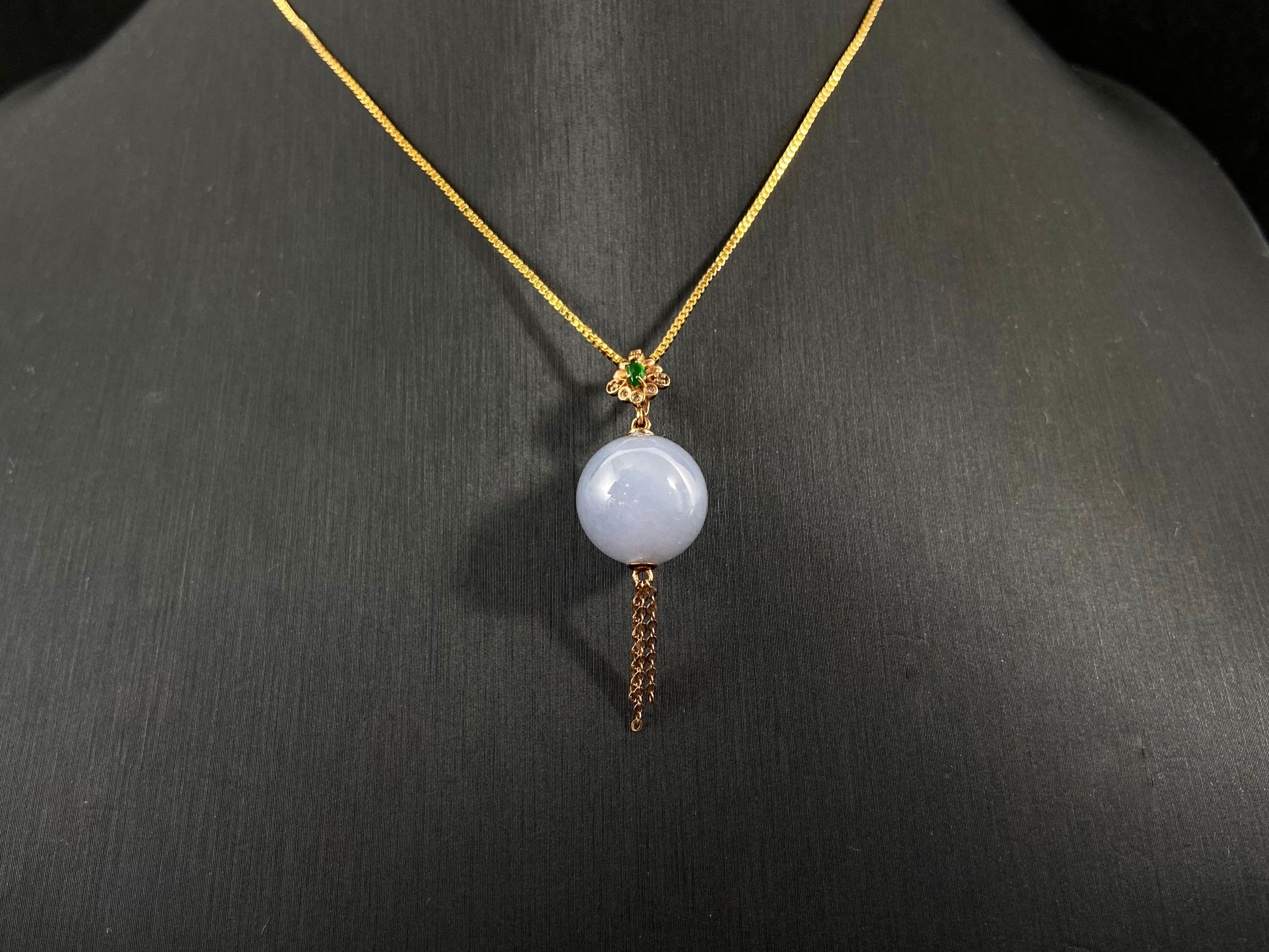 A semi transparent, milky white jade bead  Drilled bead setting with gold fittings