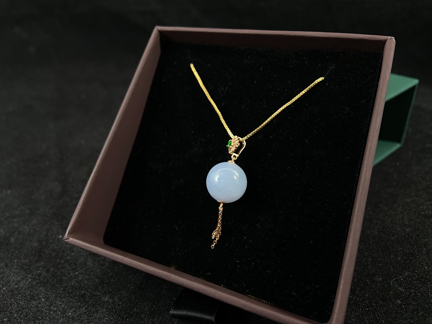 A semi-transparent, milky white jade bead is securely set using the nail-set technique