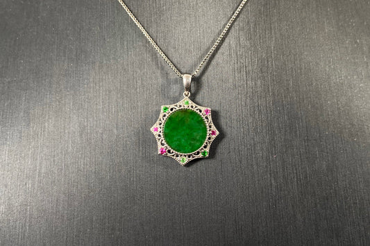 A circular imperial green jade center is elegantly encased within an octagonal frame of 18k white gold.