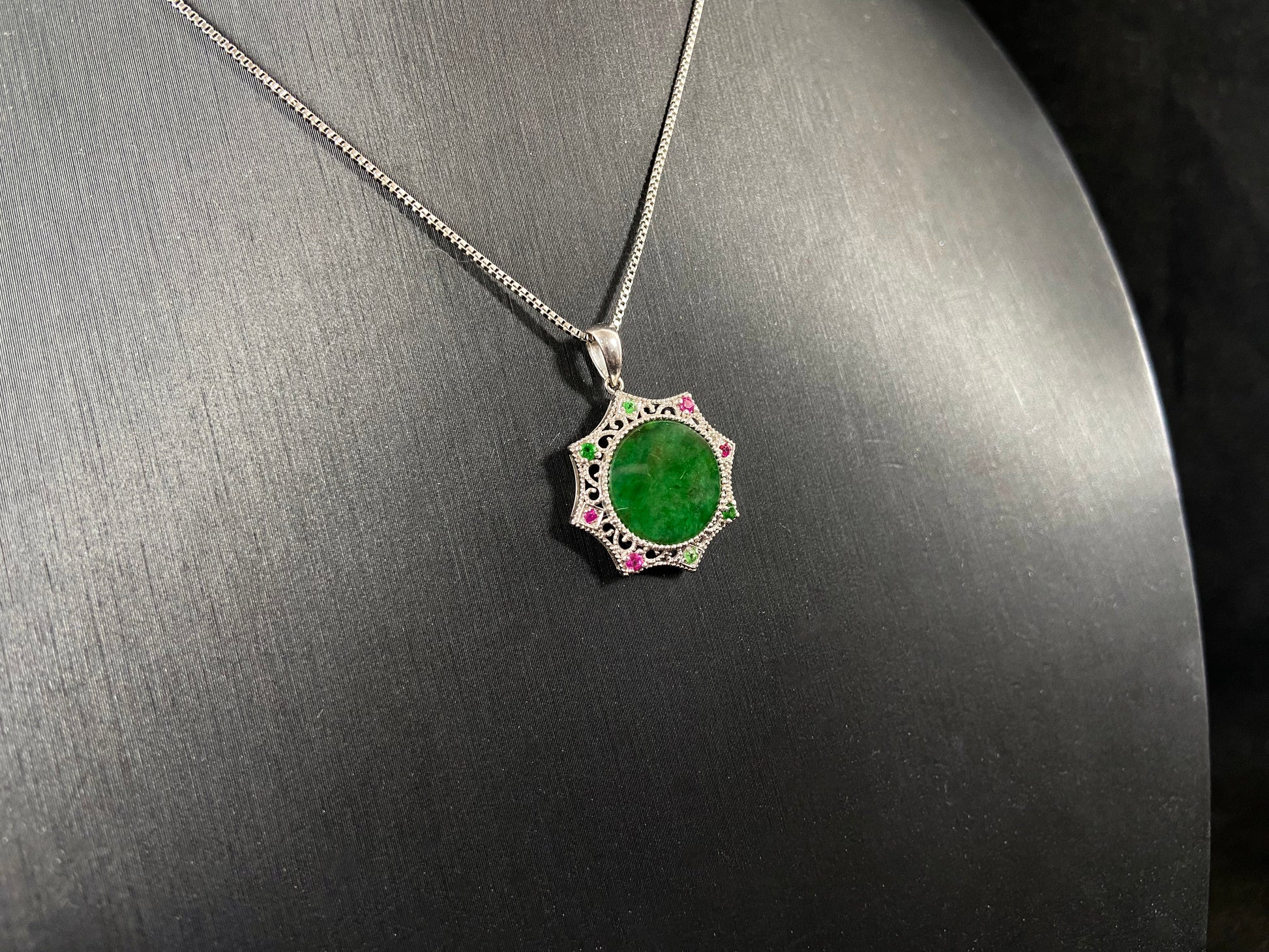 A circular imperial green jade center is elegantly encased within an octagonal frame of 18k white gold.