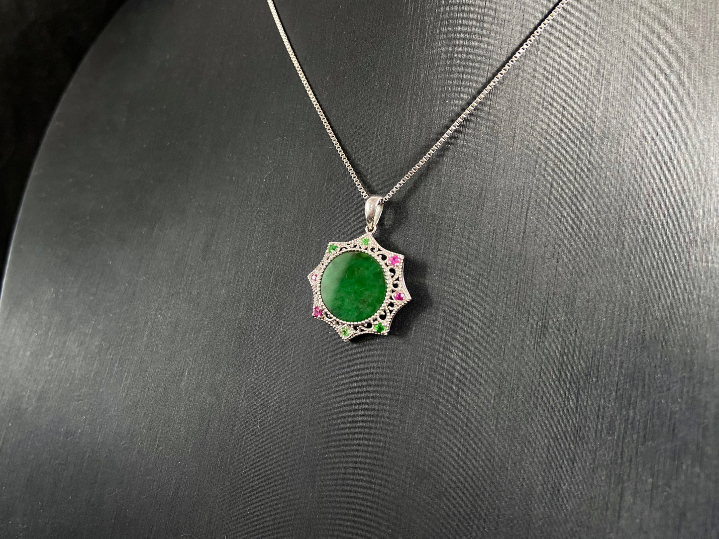 A circular imperial green jade center is elegantly encased within an octagonal frame of 18k white gold.