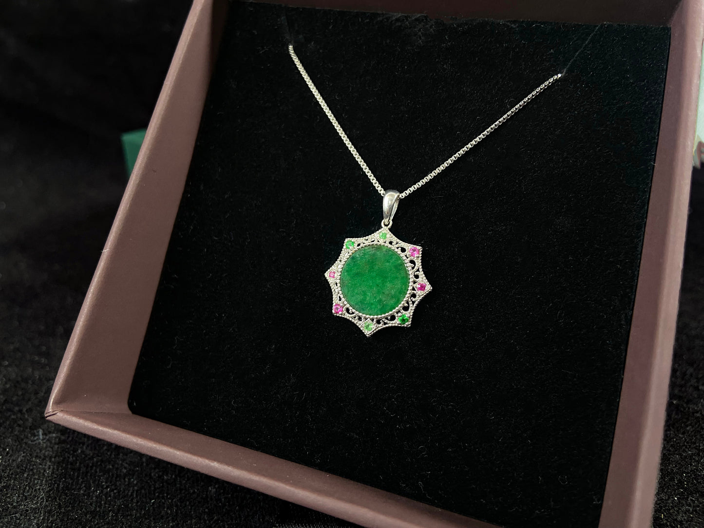 A circular imperial green jade center is elegantly encased within an octagonal frame of 18k white gold.