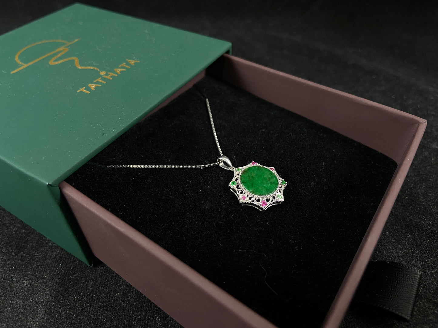 A circular imperial green jade center is elegantly encased within an octagonal frame of 18k white gold.