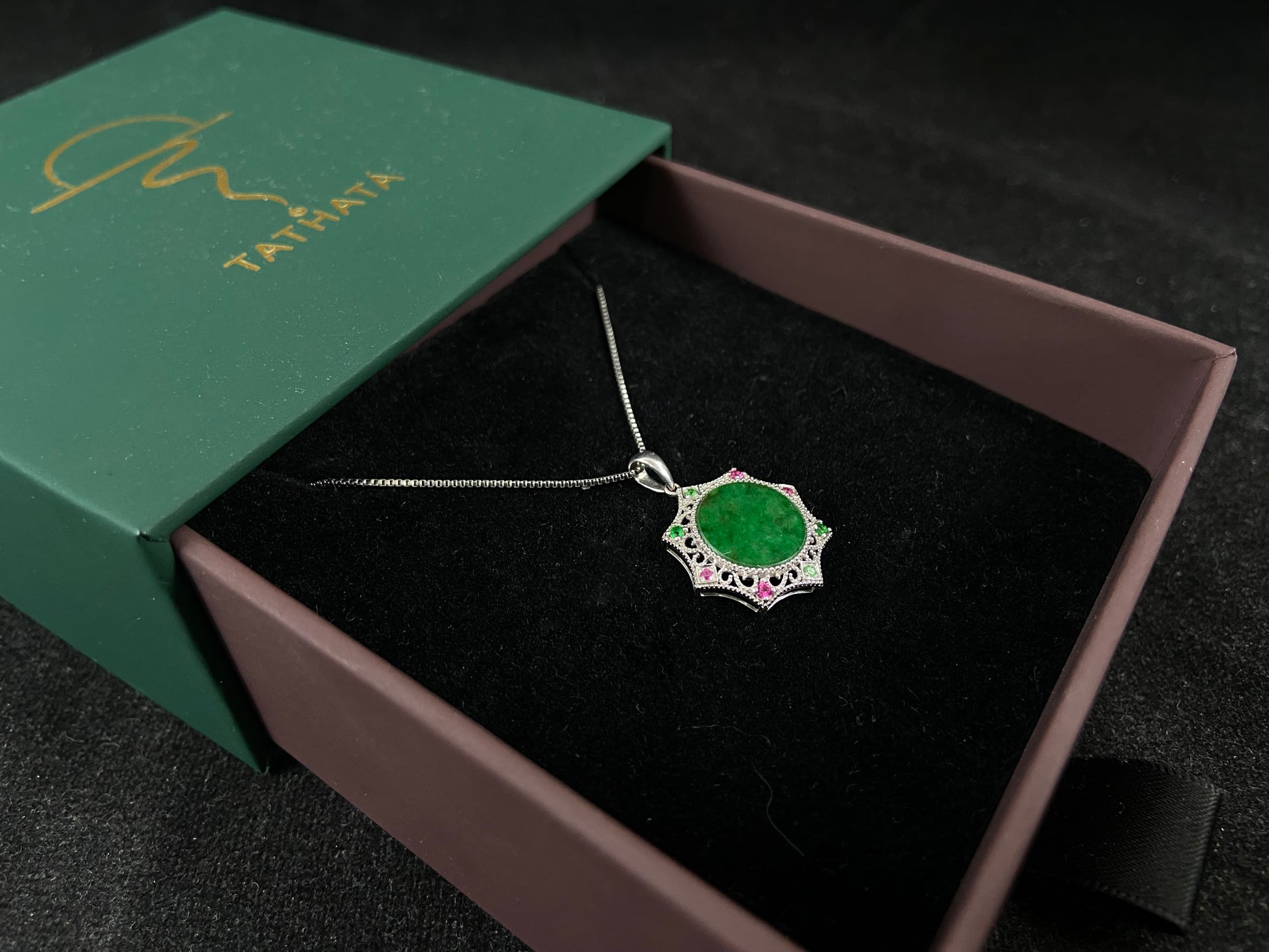 A circular imperial green jade center is elegantly encased within an octagonal frame of 18k white gold.