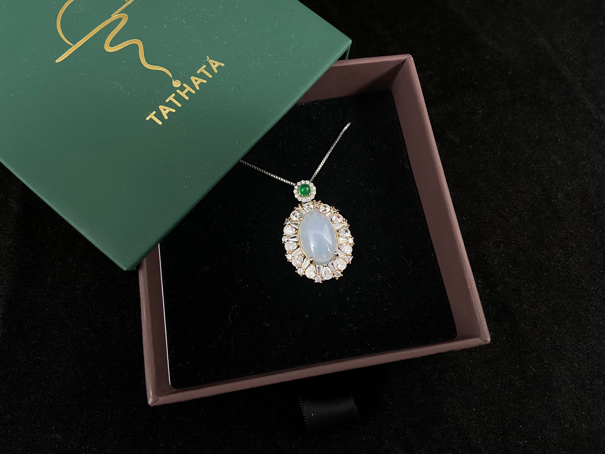An oval, semi translucent milky jade pendant is securely embraced by a 925 silver claw set frame.