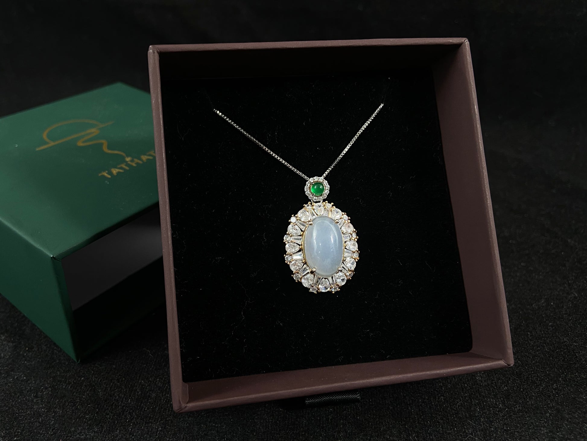 An oval, semi translucent milky jade pendant is securely embraced by a 925 silver claw set frame.