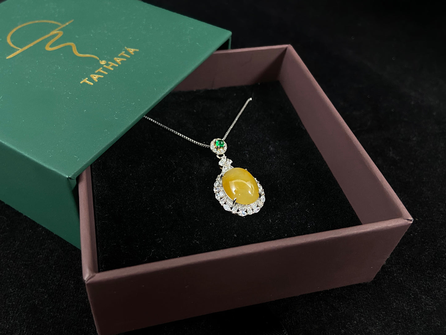 This yellow circular jade pendant features a claw set 925 silver frame that securely embraces the gemstone.