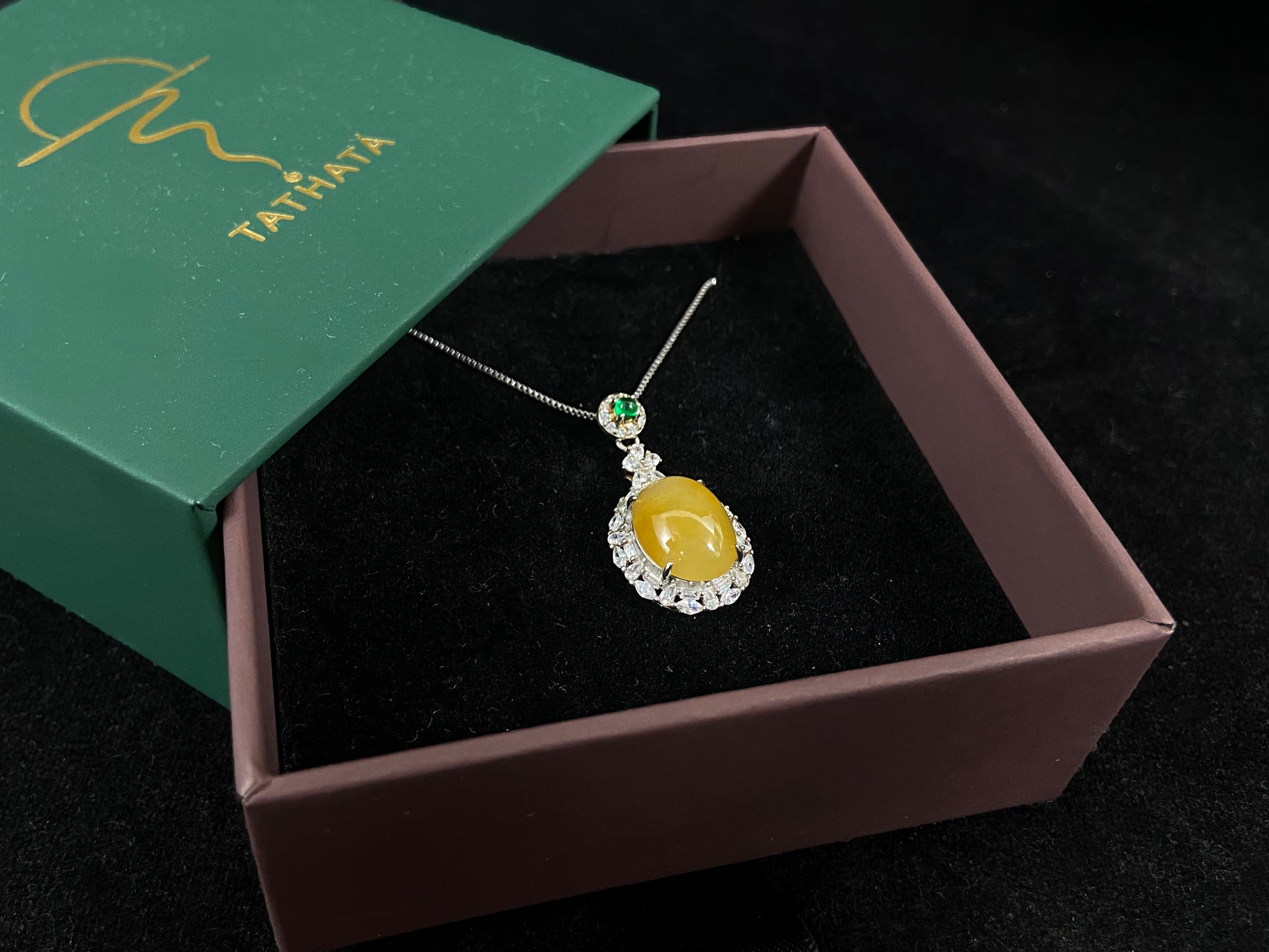 This yellow circular jade pendant features a claw set 925 silver frame that securely embraces the gemstone.