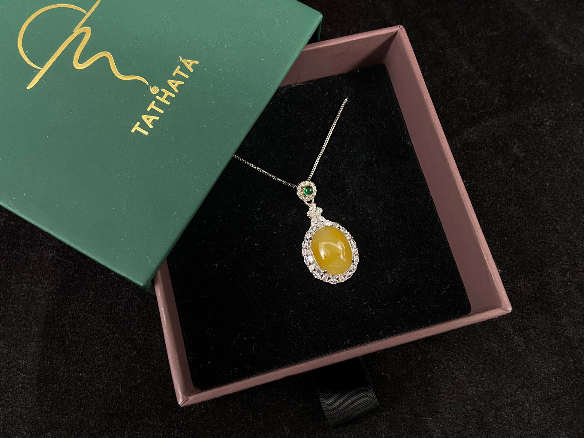 This yellow circular jade pendant features a claw set 925 silver frame that securely embraces the gemstone.