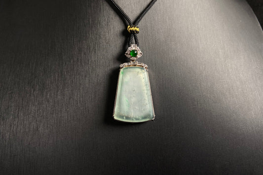 A clear light green "Wu Shi" plaque pendant, framed in 925 silver.