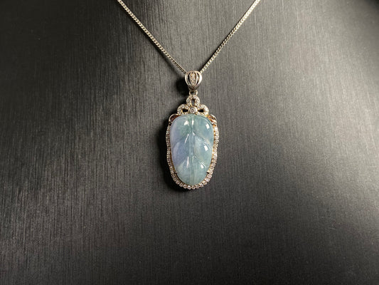 A leaf shaped jade pendant featuring translucent green blending into soft purple, elegantly framed in 925 silver.