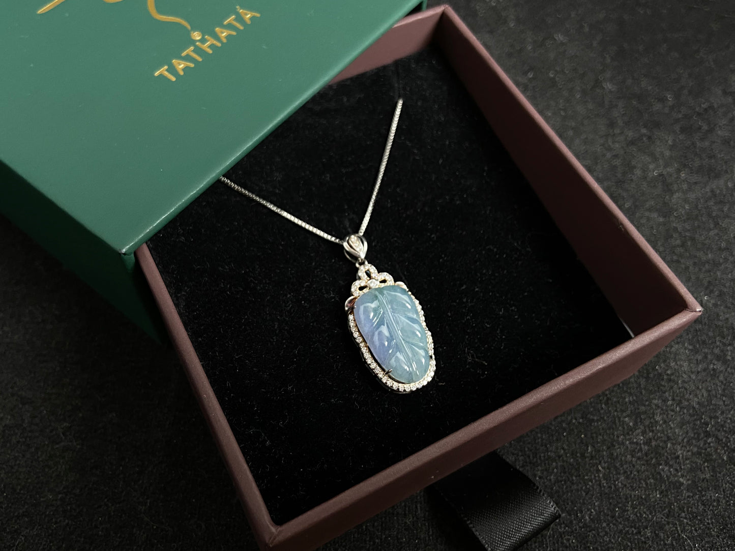 A leaf shaped jade pendant featuring translucent green blending into soft purple, elegantly framed in 925 silver.