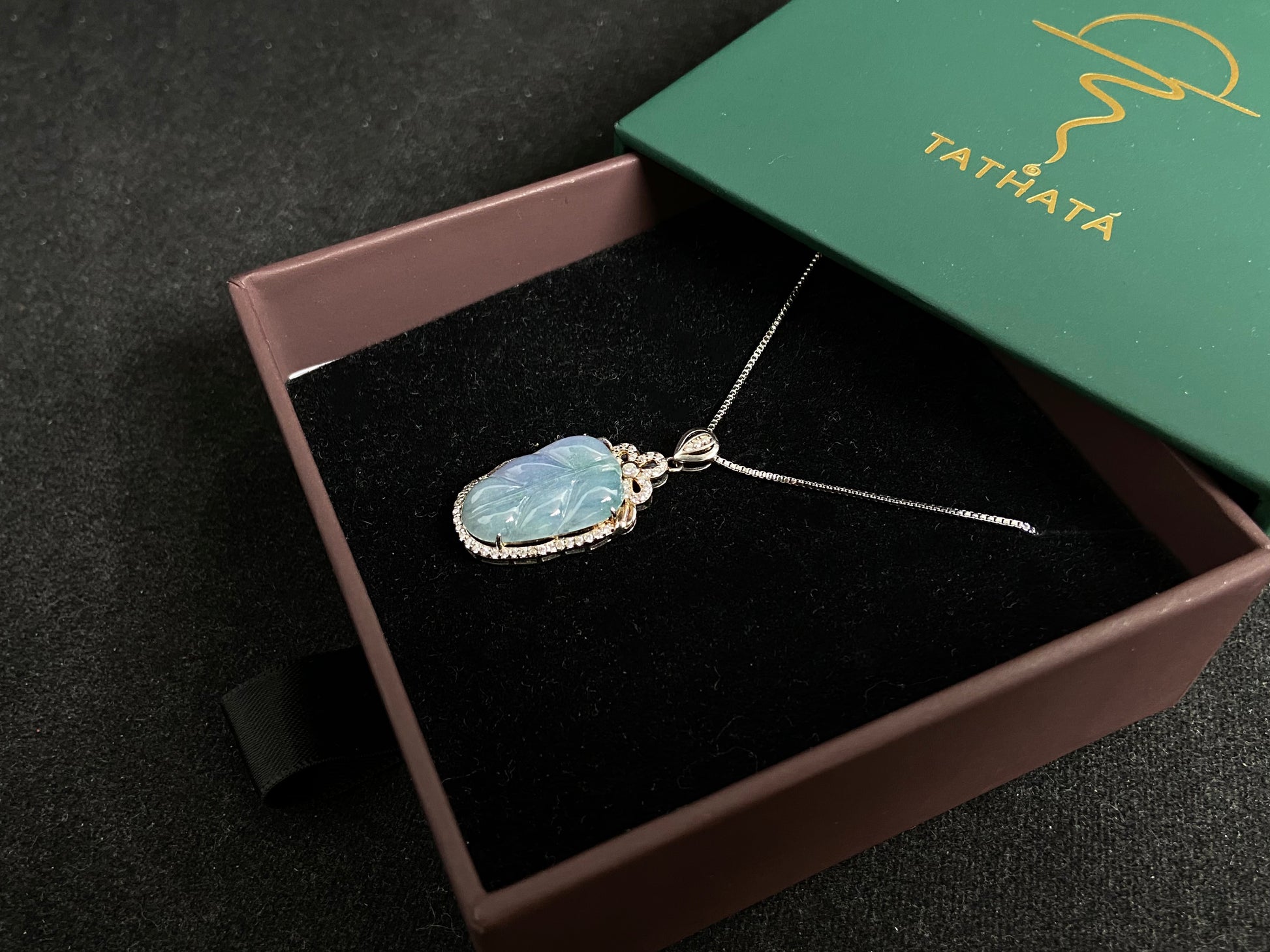 A leaf shaped jade pendant featuring translucent green blending into soft purple, elegantly framed in 925 silver.