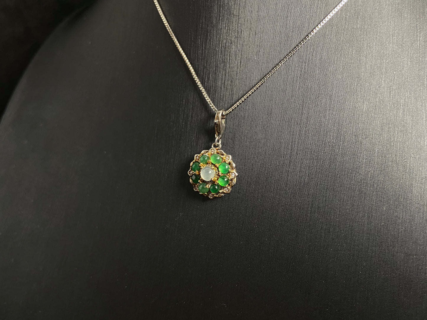 A pendant featuring a big icy center stone surrounded by eight translucent green jade beads, all set in 925 silver.