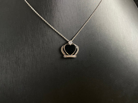 A heart shaped mystical jade pendant set in 925 silver with a diamond accent, revealing a hidden green glow when illuminated.