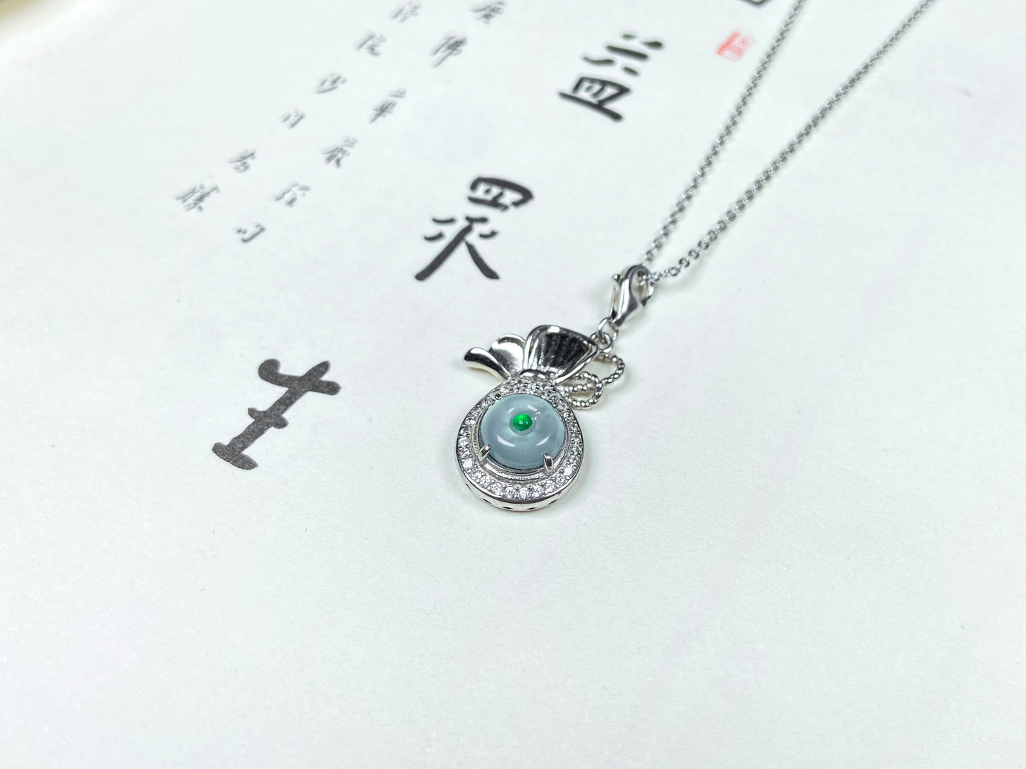 A icy green wealth pouch jadeite pendant.