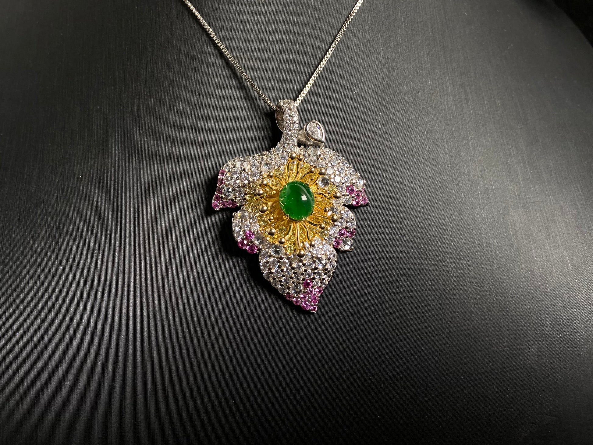 A 925 silver leaf pendant with gold and rose gold plating, centered with an imperial green jade bead.