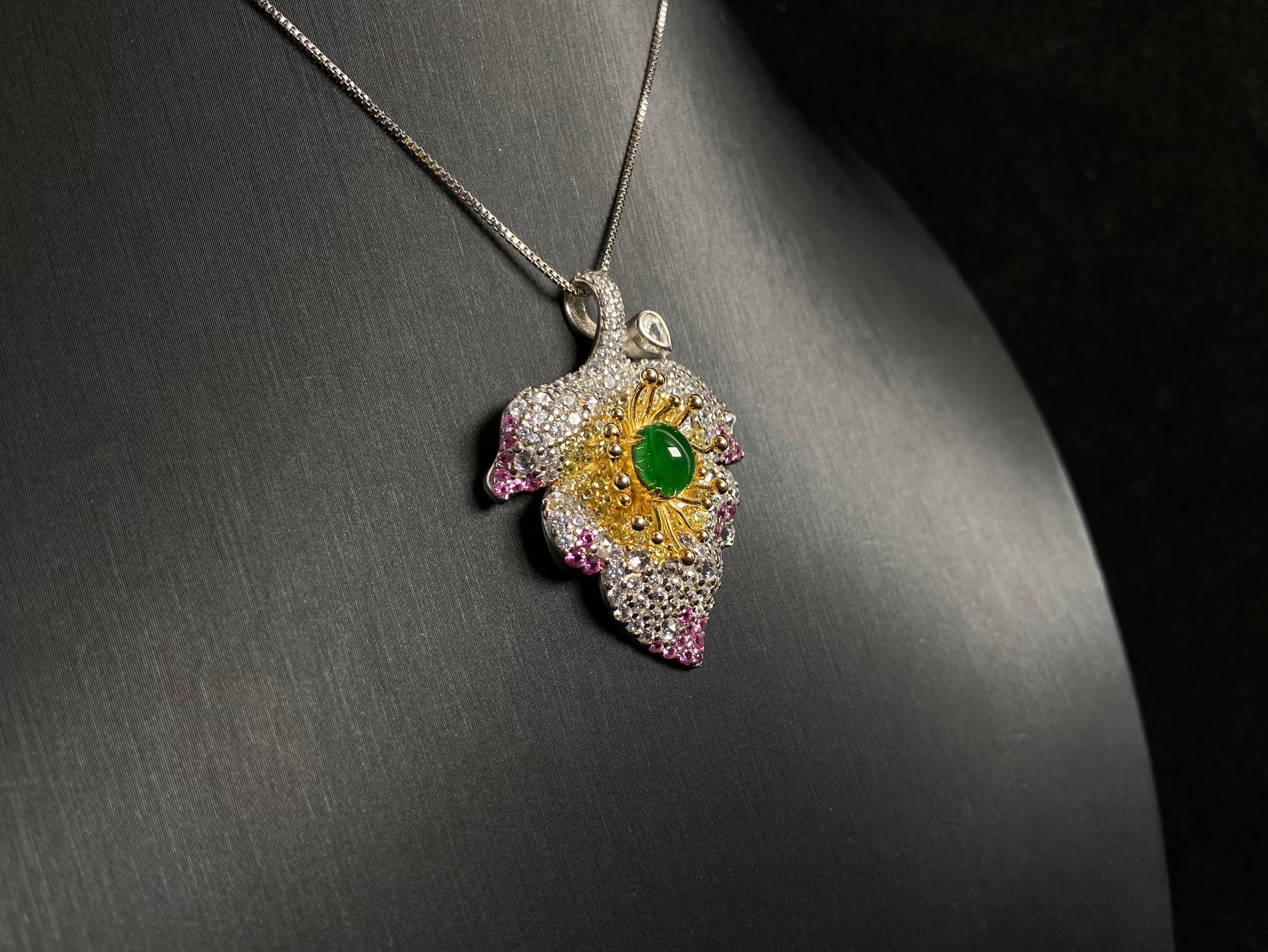 A 925 silver leaf pendant with gold and rose gold plating, centered with an imperial green jade bead.