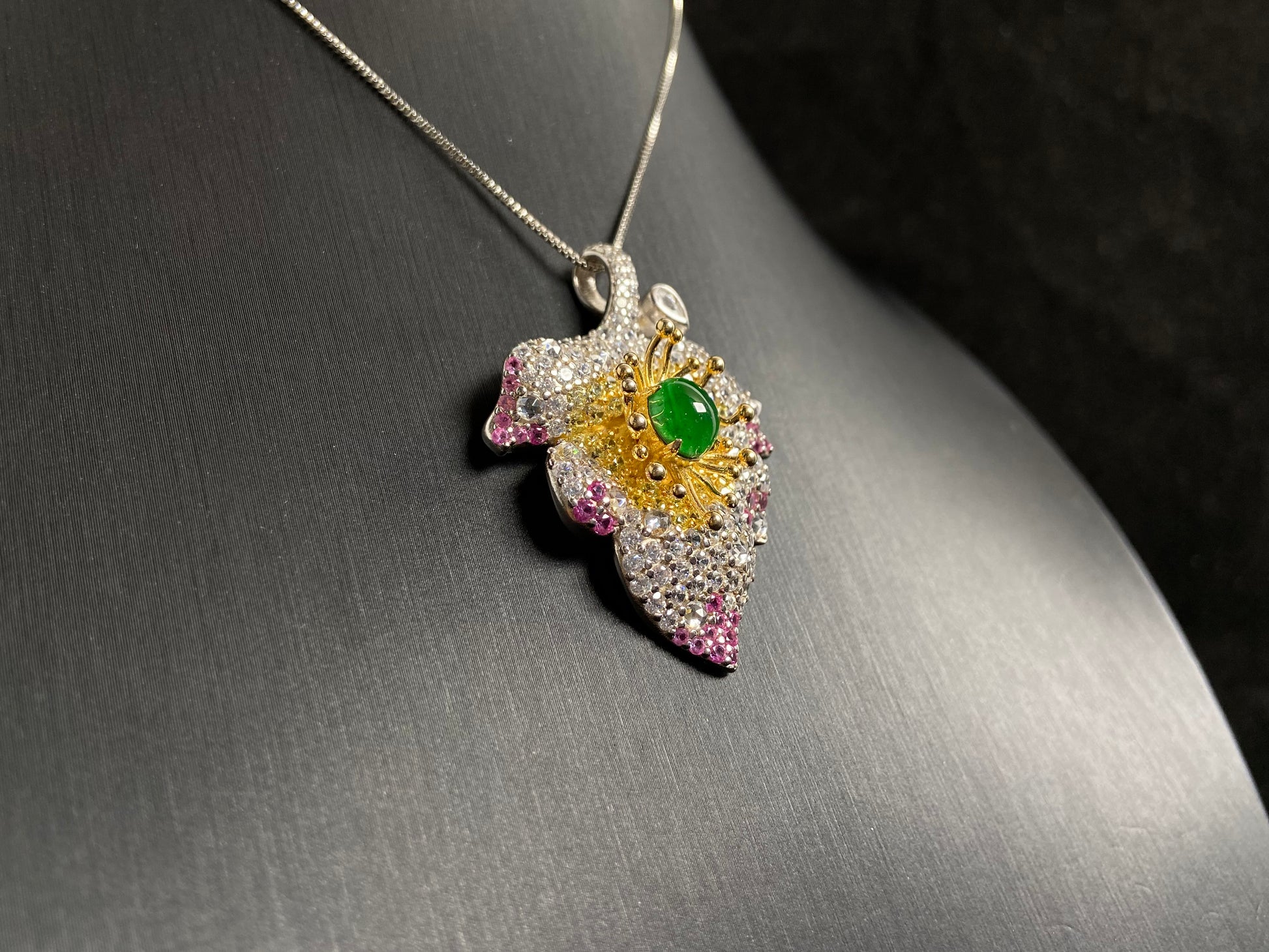 A 925 silver leaf pendant with gold and rose gold plating, centered with an imperial green jade bead.