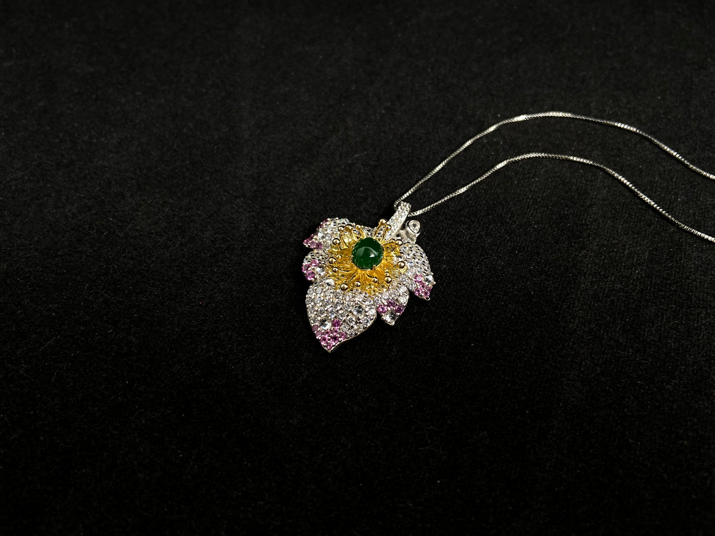 A 925 silver leaf pendant with gold and rose gold plating, centered with an imperial green jade bead.
