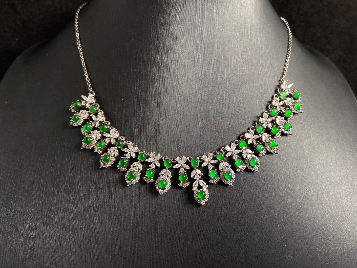 A fox shaped pendant featuring 34 imperial green translucent jade beads with 925 silver petal and leaf accents.