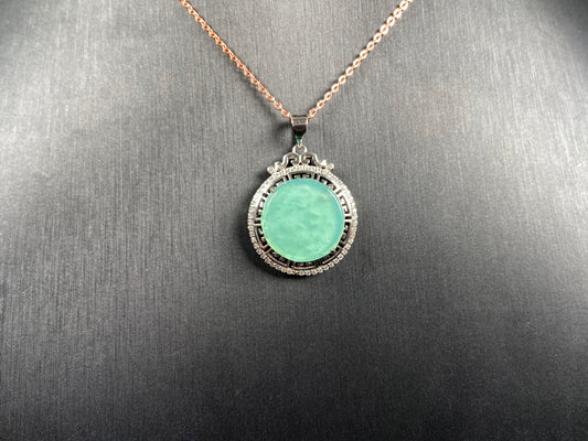 A icy mint green round jadeite pendant.