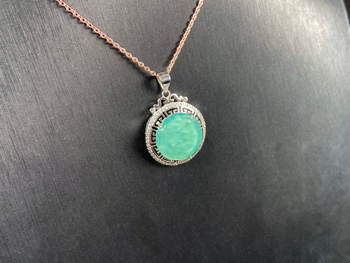 A icy mint green round jadeite pendant.