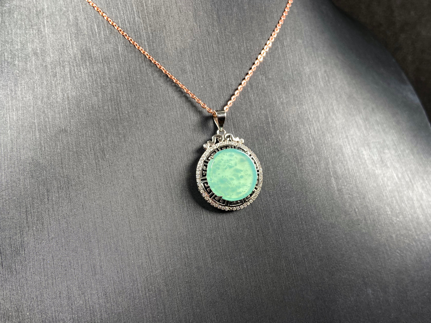 A icy mint green round jadeite pendant.